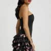 Vestido corto sin tirantes con volantes y corte corsé en negro con estampado floral