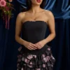 Vestido corto sin tirantes con volantes y corte corsé en negro con estampado floral