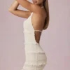 Vestido corto Tarryn con volantes, espalda descubierta y cuello halter en color marfil