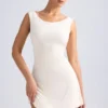 Vestido corto Tigen con hombros descubiertos, espalda con volantes y corte en A en color marfil