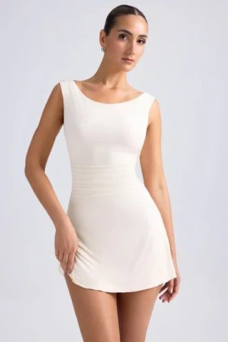 Vestido corto Tigen con hombros descubiertos, espalda con volantes y corte en A en color marfil