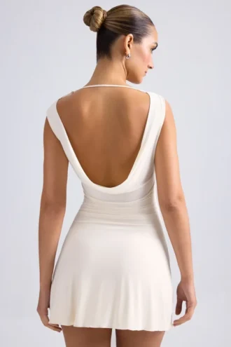Vestido corto Tigen con hombros descubiertos, espalda con volantes y corte en A en color marfil
