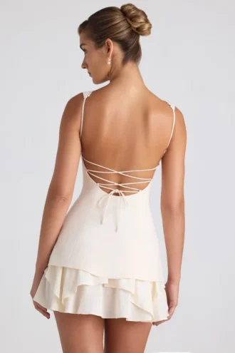 Vestido corto tipo corsé con volantes y botones Cassandra en color marfil