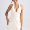 Vestido corto tulipán estructurado con cuello halter Harmonia en color marfil