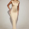 Vestido largo de satén con cuello barco y espalda cruzada de Hivera en color champán