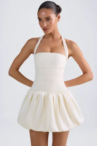 Vestido micro corto con corsé, cuello halter y bajo abullonado con cordones Ludmila en color marfil