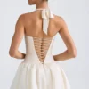 Vestido micro corto con corsé, cuello halter y bajo abullonado con cordones Ludmila en color marfil