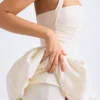 Vestido micro corto con corsé, cuello halter y bajo abullonado con cordones Ludmila en color marfil