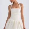 Vestido micro corto con corsé, cuello halter y bajo abullonado con cordones Ludmila en color marfil