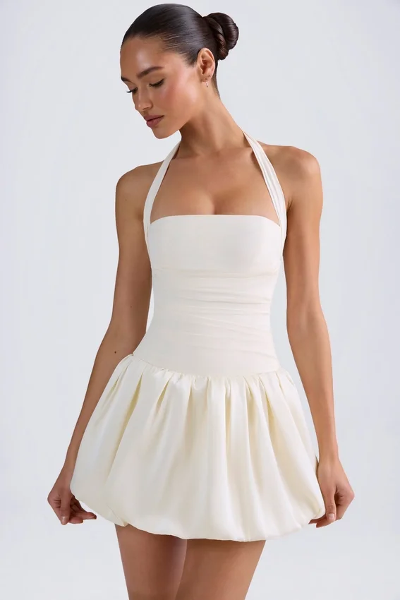 Vestido micro corto con corsé, cuello halter y bajo abullonado con cordones Ludmila en color marfil