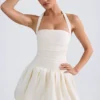 Vestido micro corto con corsé, cuello halter y bajo abullonado con cordones Ludmila en color marfil